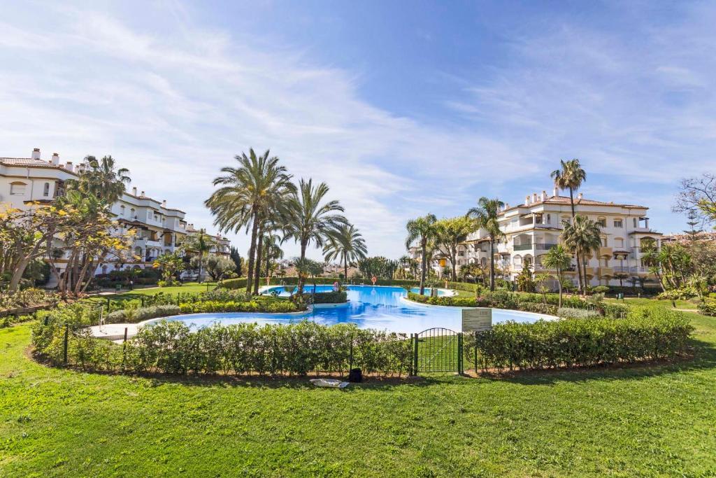 ein Resortpool mit Palmen und Gebäuden in der Unterkunft 2034 Hacienda Nagueles I Marbella Golden Mile in Marbella