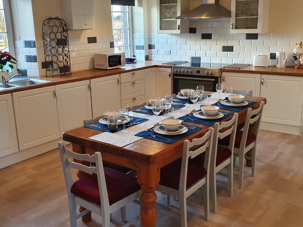 una cucina con tavolo in legno e bicchieri da vino di Lovely Cottage on Hadrians Wall 12 Miles From Carlisle a Carlisle