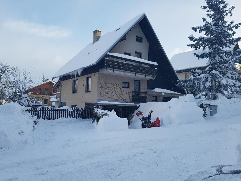 una casa cubierta de nieve junto a una valla en Apartmán Astomo, en Vrchlabí