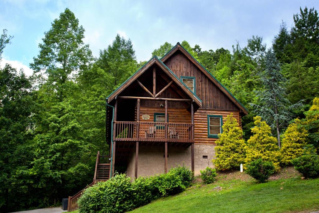 a cabin in the woods with a balcony at A Timeless Event in Pigeon Forge