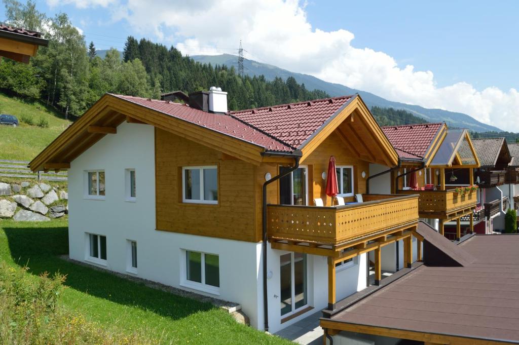 una fila de casas con balcones de madera. en Haus Klein Rosental, en Neukirchen am Großvenediger