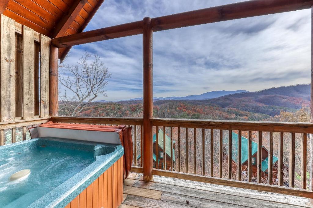 a hot tub on a deck with a view of the mountains at Blue Ridge Sunrise in Pigeon Forge