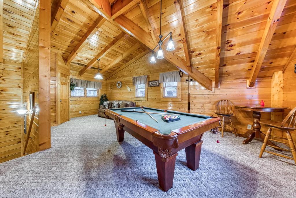 a pool table in a room with wooden walls at Blackberry Cobbler in Pigeon Forge