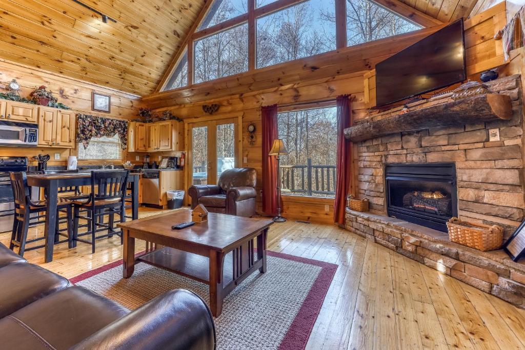 a living room with a fireplace in a log cabin at Seasons of the Heart in Gatlinburg