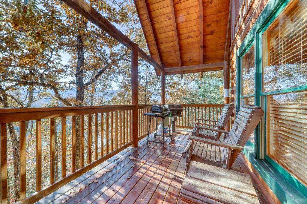 a porch with two chairs and a grill on it at Treehouse in Pigeon Forge