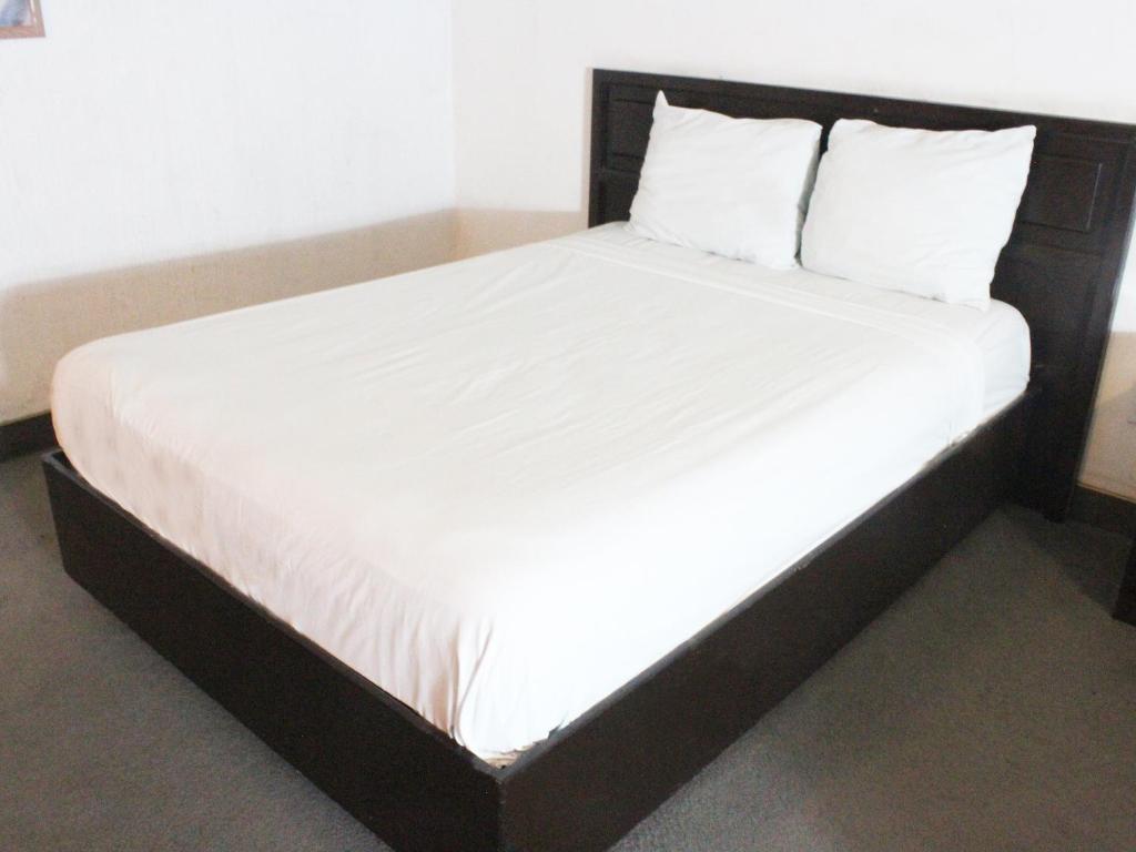 a white bed sitting in a room next to a wall at Hotel Fiesta Tijuana in Tijuana