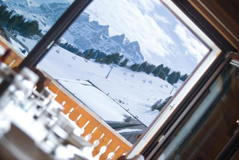 a view of a snow covered mountain through a window at B&B Chalet Rey-Bellet in Les Crosets