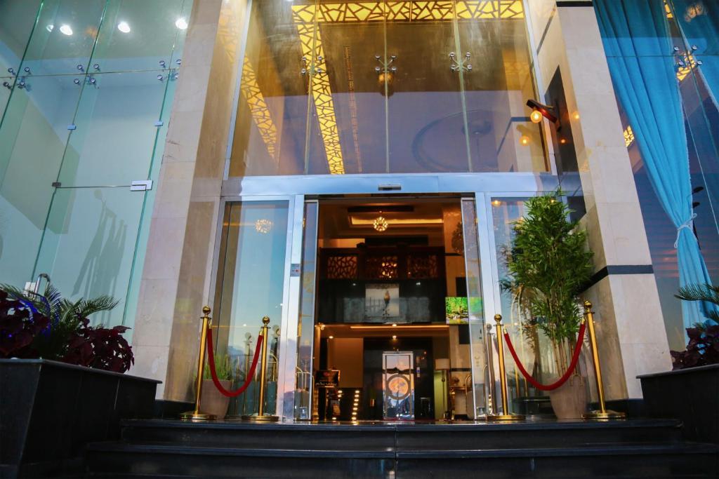 un hall d'un bâtiment avec des plantes rouges et vertes dans l'établissement Grand House, à Abha