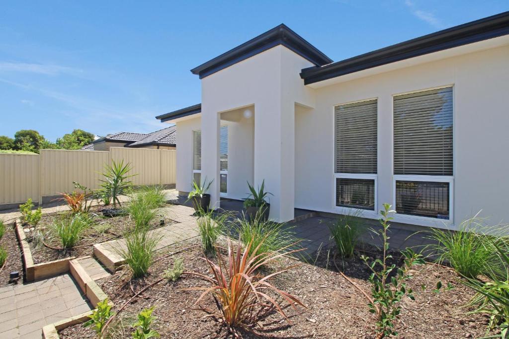 a home with a white house with plants at Aldinga Beach Experience - C21 SouthCoast Holidays in Aldinga Beach