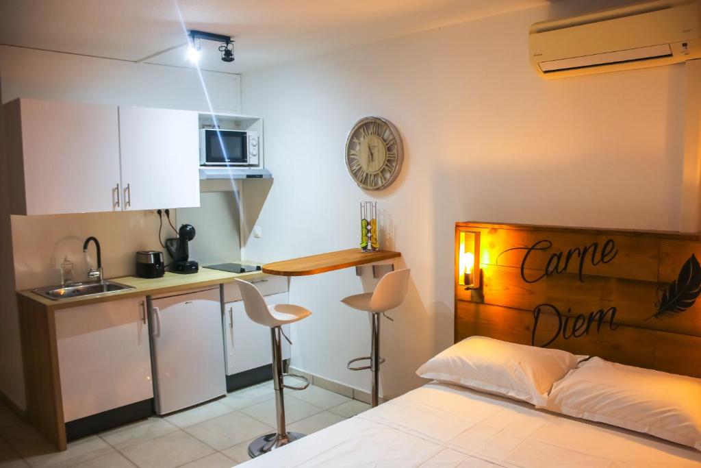 sypialnia z łóżkiem i stołem oraz kuchnia w obiekcie CHARMANT STUDIO DE STANDING GOSIER w mieście Le Gosier