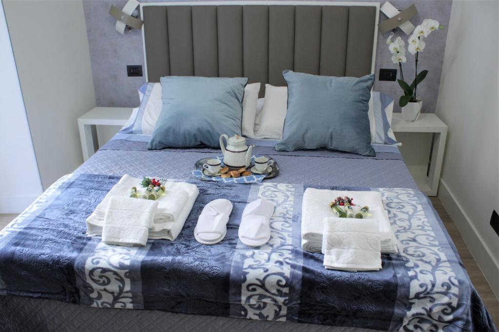a bed with two towels and a tray of food at Napoli Mariana Luxury in Naples