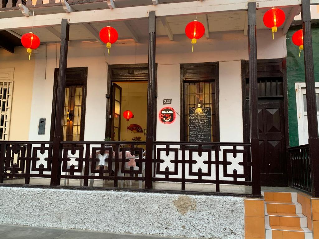 a building with a fence and red lanterns at Hospedaje felicita in Pimentel