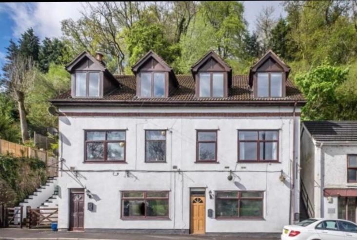 a white house with windows and a car parked in front of it at Wye View in Tintern