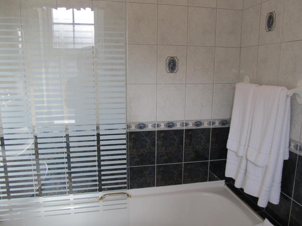 a bathroom with a tub and a window and towels at Neidin House in Kenmare
