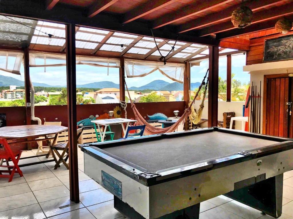 una mesa de billar en un patio con mesa y sillas en Barra Surf Hostel Florianopolis, en Florianópolis
