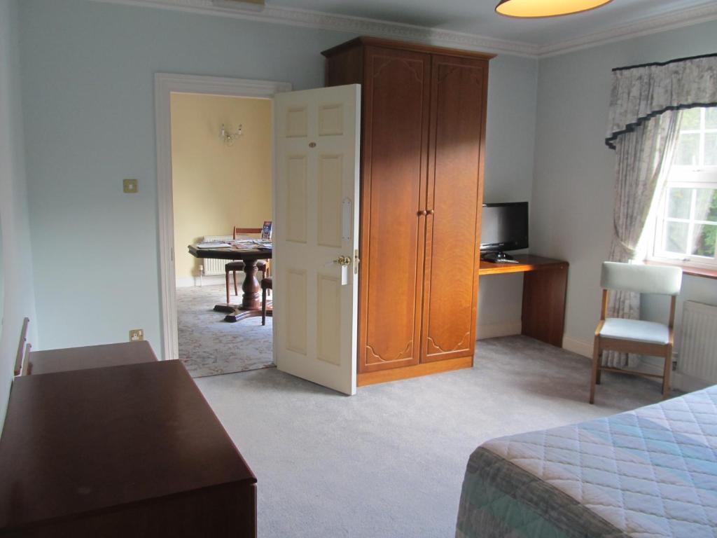 a bedroom with a bed and a dining room with a table at Neidin House in Kenmare