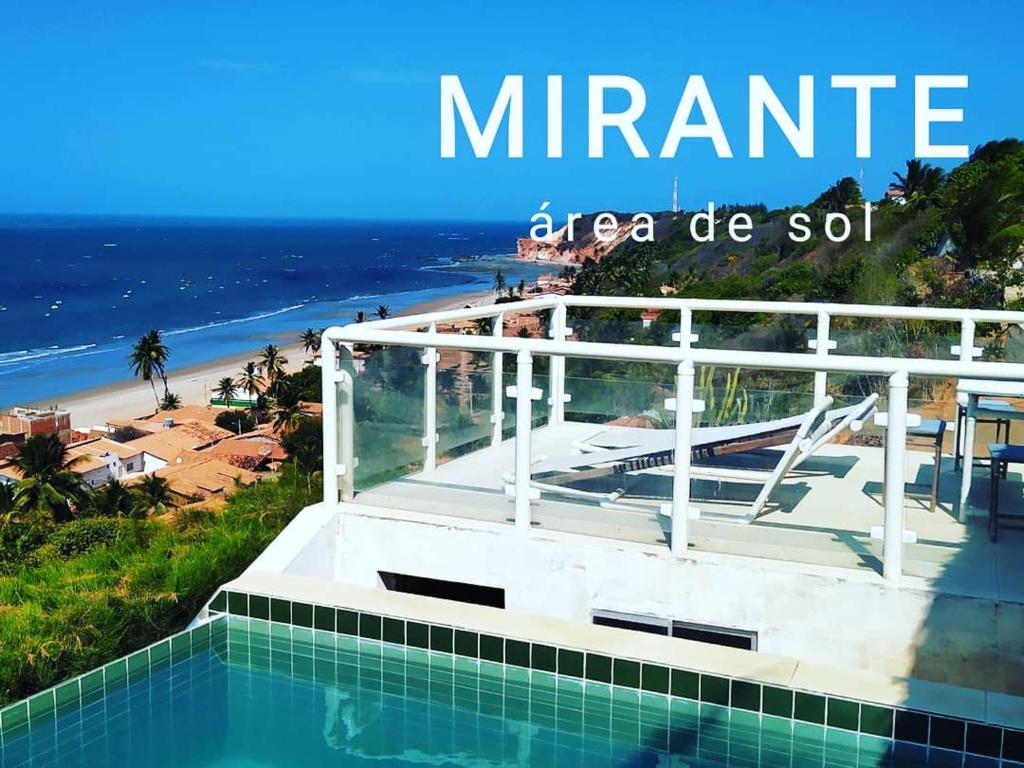 a swimming pool with a view of a beach at Chalés Mirante do Mar in Redonda