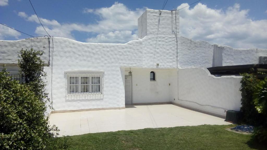 a white building with a door in a yard at Buen Descanso in Salta