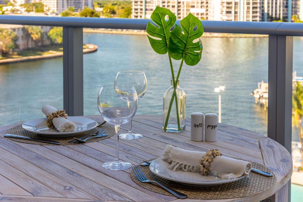 uma mesa com pratos e copos de vinho numa varanda em Espectacular Condo Esquina Beach House Hollywood Apartamento em Hollywood