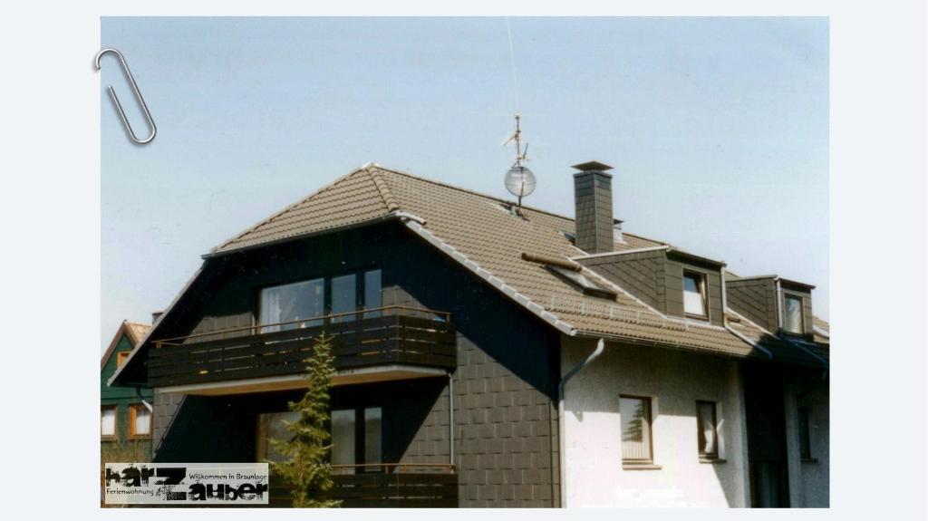 a house with a shingled roof and a street light at Ferienwohnung harZauber in Braunlage