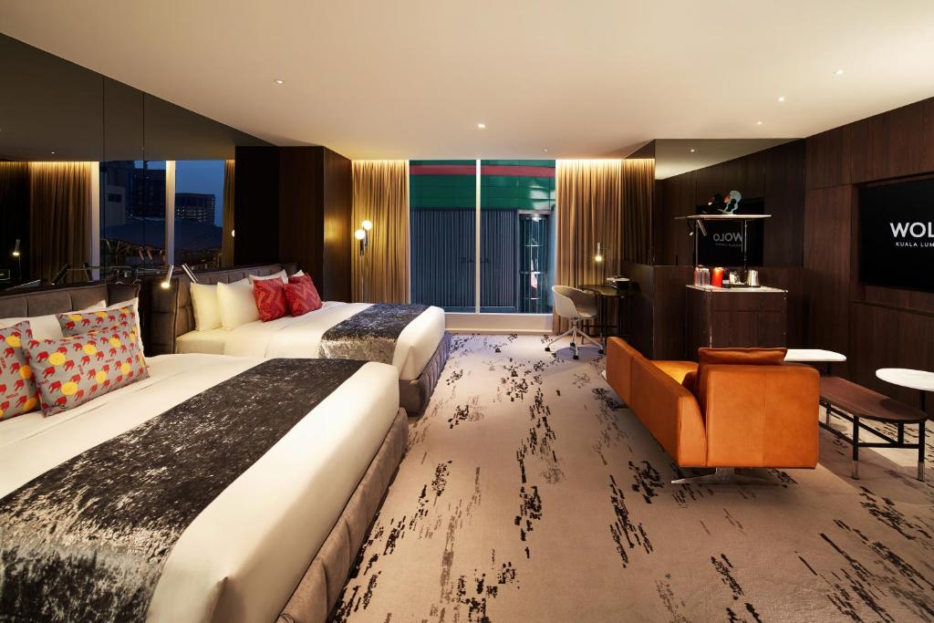 een hotelkamer met 2 bedden en een bureau bij WOLO Kuala Lumpur in Kuala Lumpur