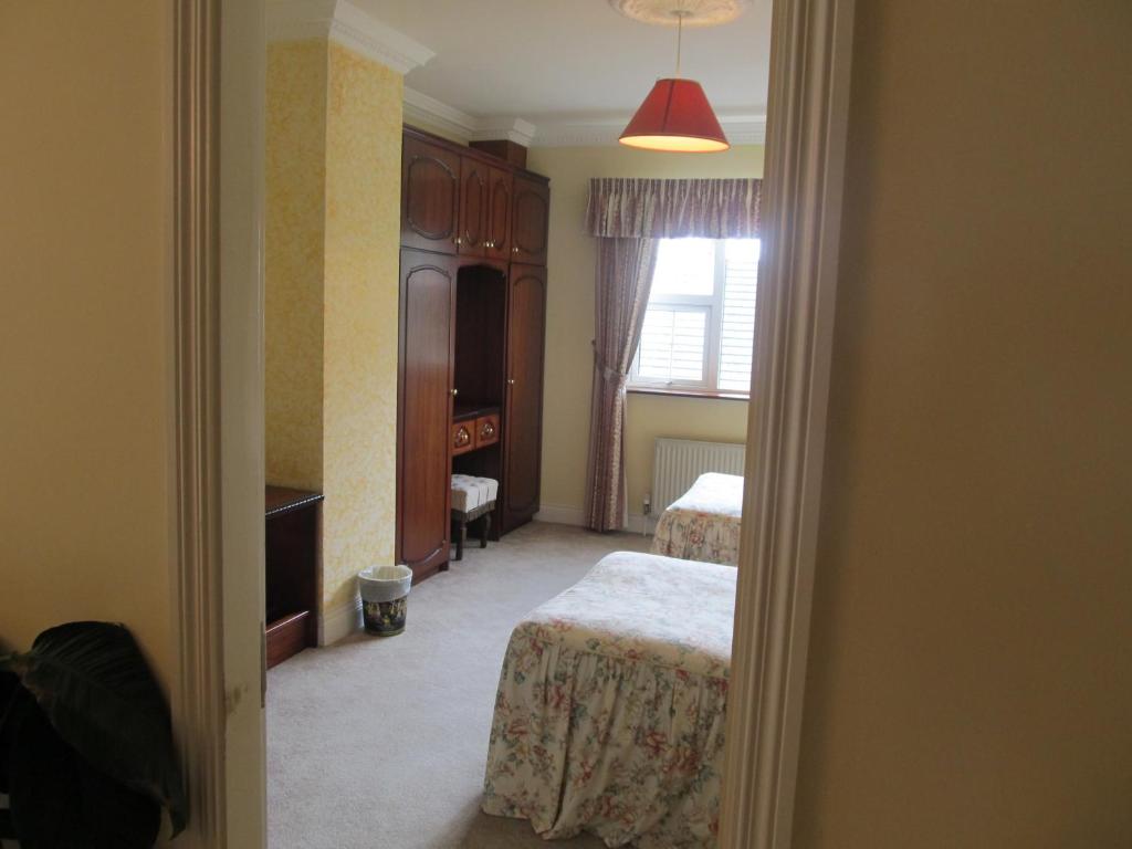 a bedroom with two beds and a table in a room at Neidin House in Kenmare