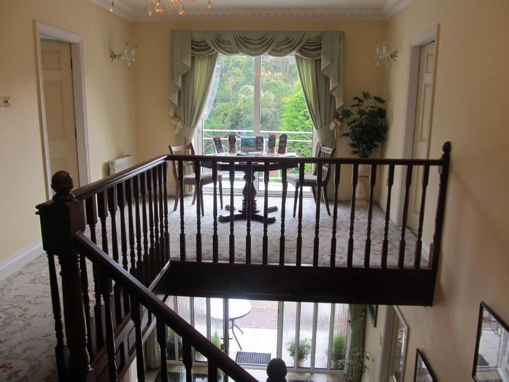 a staircase in a house with a table and a window at Neidin House in Kenmare