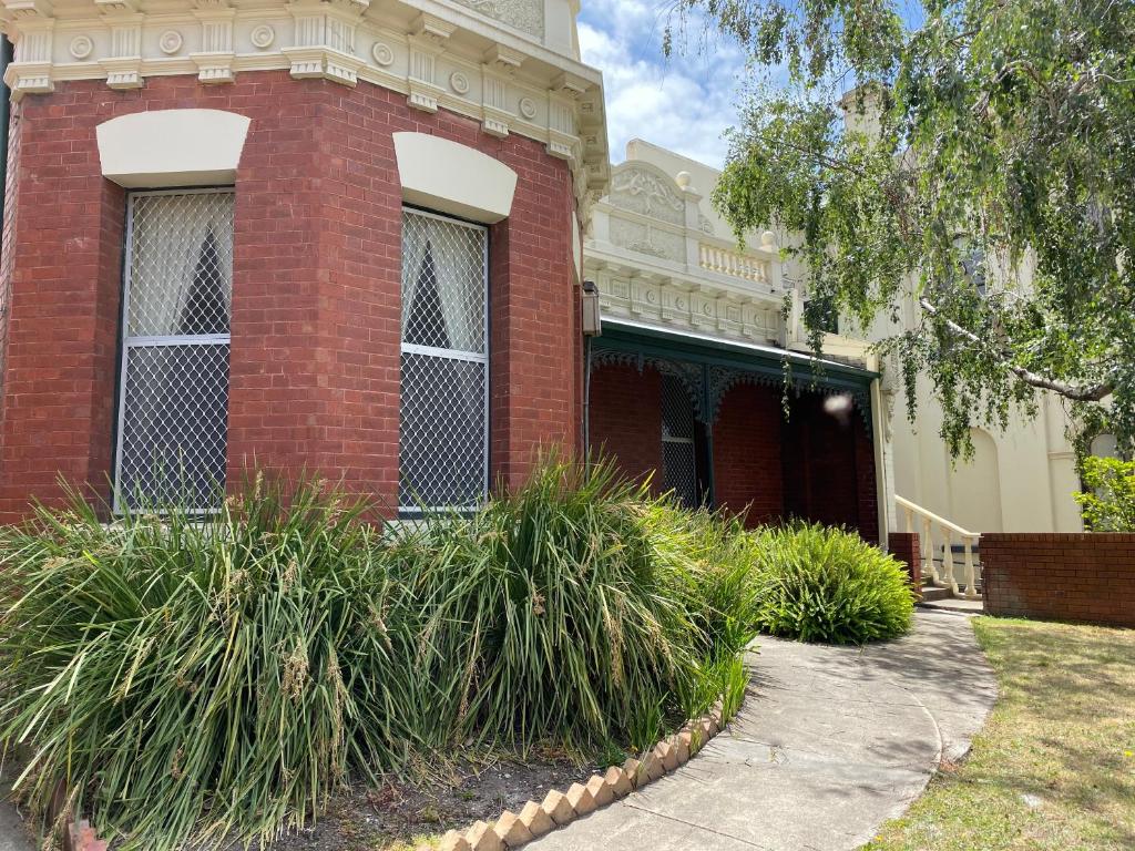 un edificio de ladrillo rojo con plantas delante de él en St. Elizabeth's Home, en Melbourne