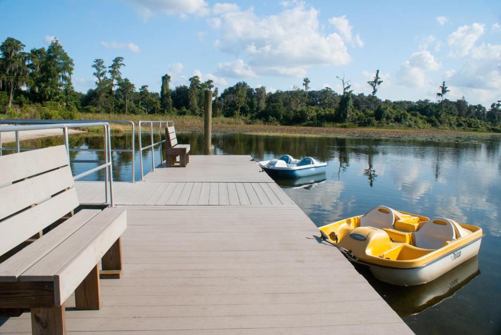 a wooden dock with a boat on the water at Grand Lake & Lifetime of Vacations Resorts in Orlando