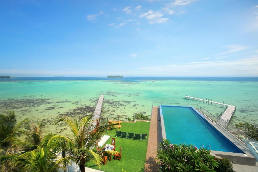 an aerial view of a swimming pool and the ocean at Royal Ocean Resort Karimunjawa in Karimunjawa