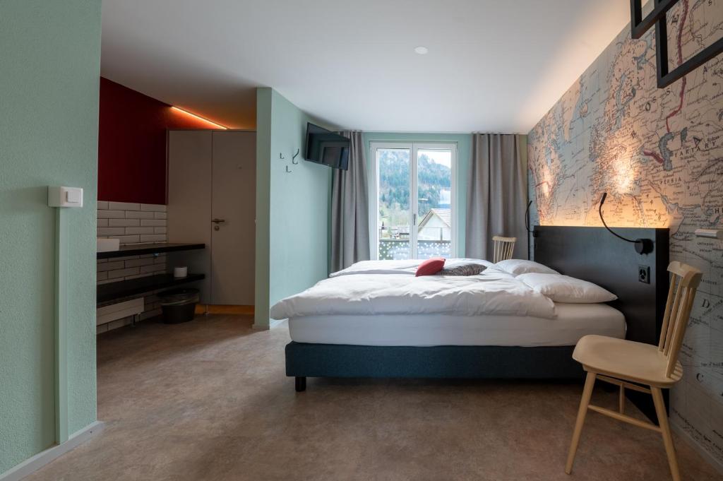 Un dormitorio con una cama grande y una ventana en Emma's B&B - Self Check-in Hotel, en Lungern