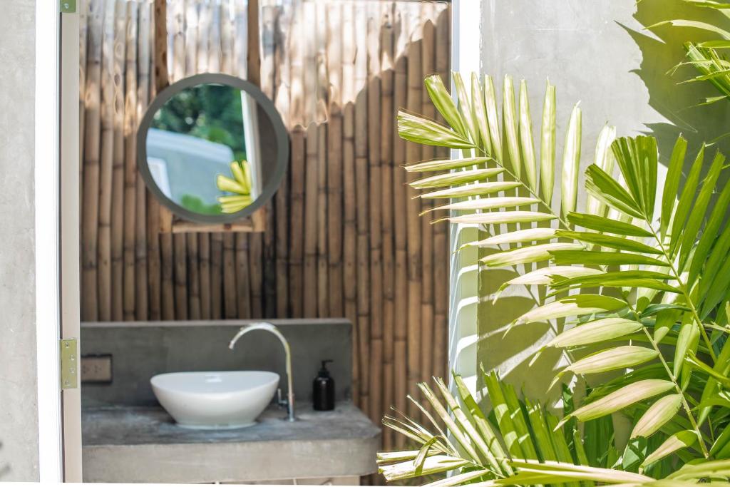 a bathroom with a sink and a mirror and a plant at Roost Glamping - SHA Certified in Rawai Beach