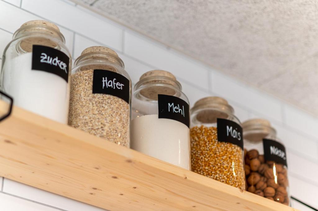 a shelf with jars filled with different types of food at Emma's B&B - Self Check-in Hotel in Lungern