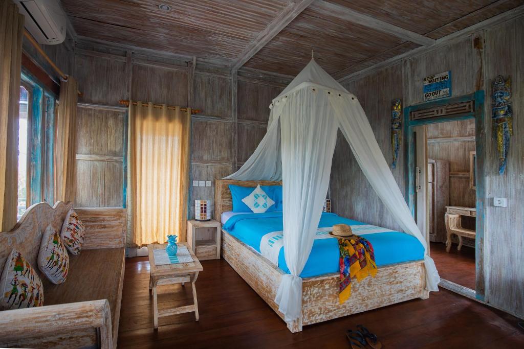 a bedroom with a bed with a canopy at Golden Hill Cottage Nusa Penida in Nusa Penida
