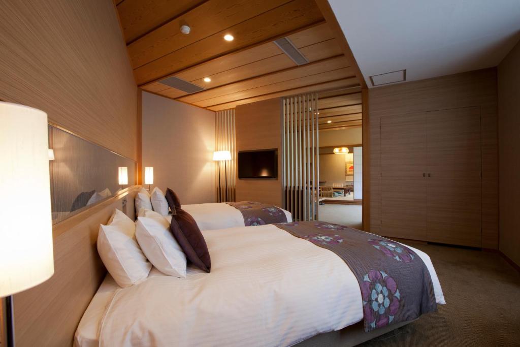 a large bedroom with two beds with white sheets and pillows at Miyajima Grand Hotel Arimoto in Miyajima