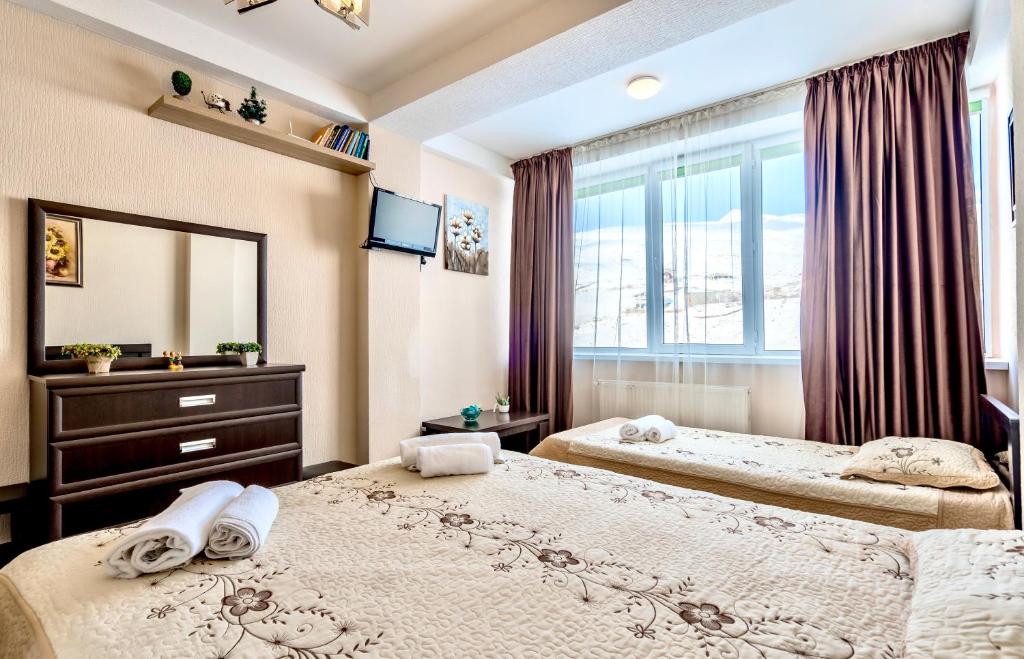 2 camas en un dormitorio con ventana en 2-room Apartment NFT Gudauri Penta 503, en Gudauri