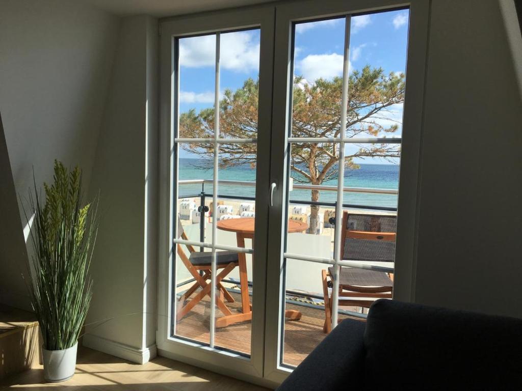 a sliding glass door with a view of the ocean at Seeblick 1 in Dahme