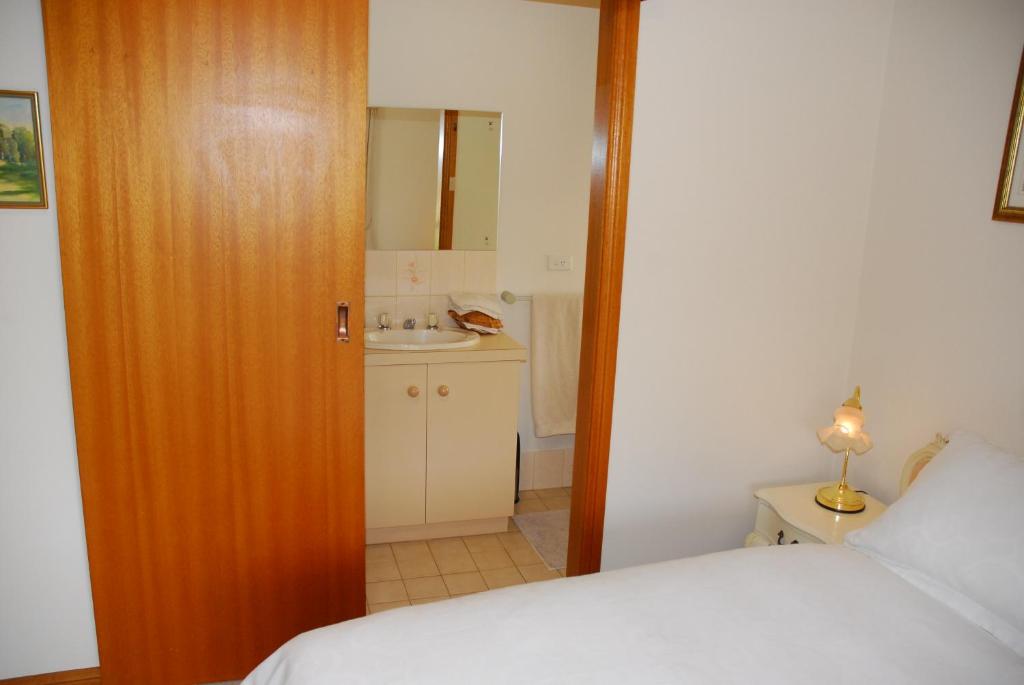 a bedroom with a bed and a bathroom with a sink at Gaerwood B&B in Keith
