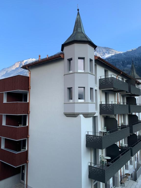 an apartment building with a turret on the side of it at Emma's B&B - Self Check-in Hotel in Lungern
