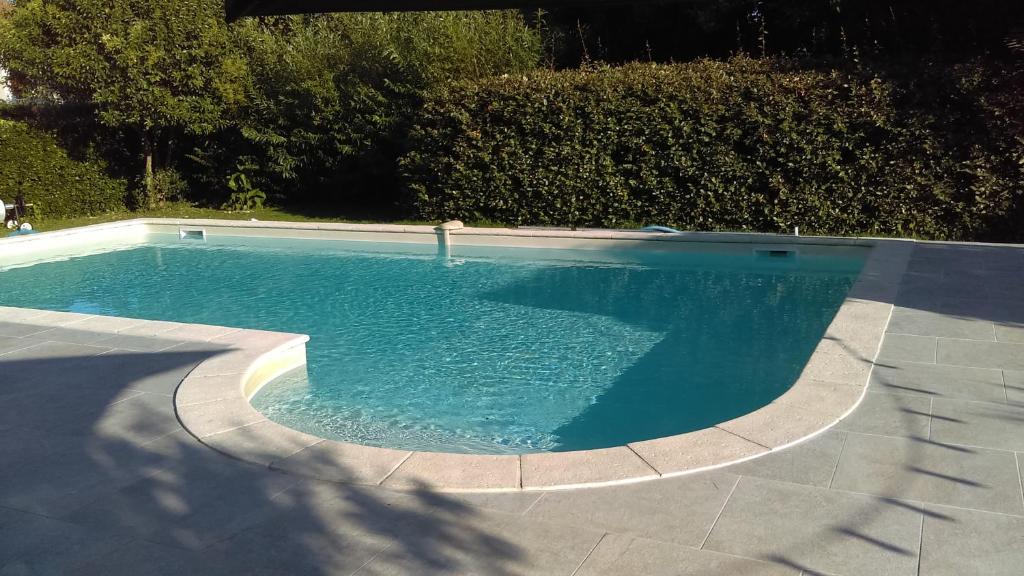 a swimming pool with blue water in a yard at Le Grenier de Gaston in Thouars-sur-Garonne