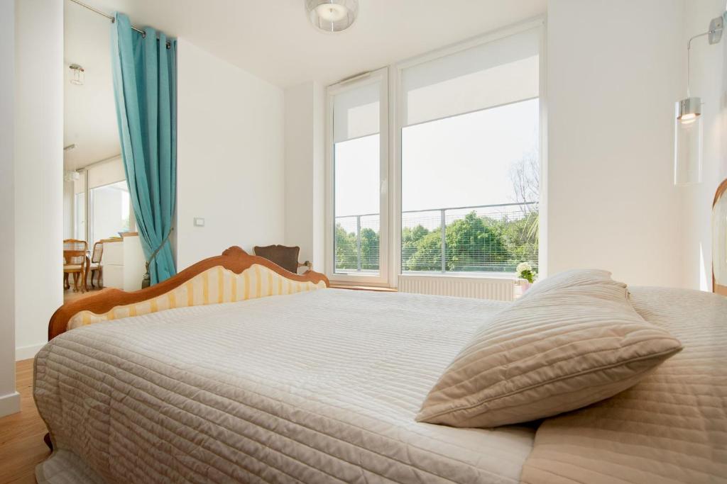 a bedroom with a bed with a large window at Central Apartment in Birštonas