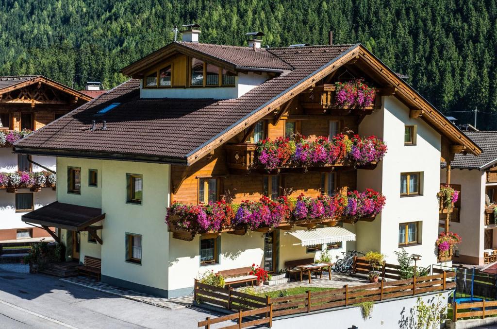 an apartment building with flowers on the balconies at Pension Bergwelt in Neustift im Stubaital