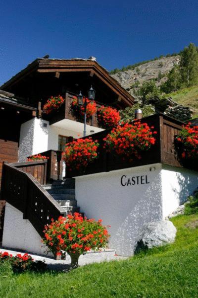 a building with red flowers on the side of it at Castel Appartemente in Saas-Grund