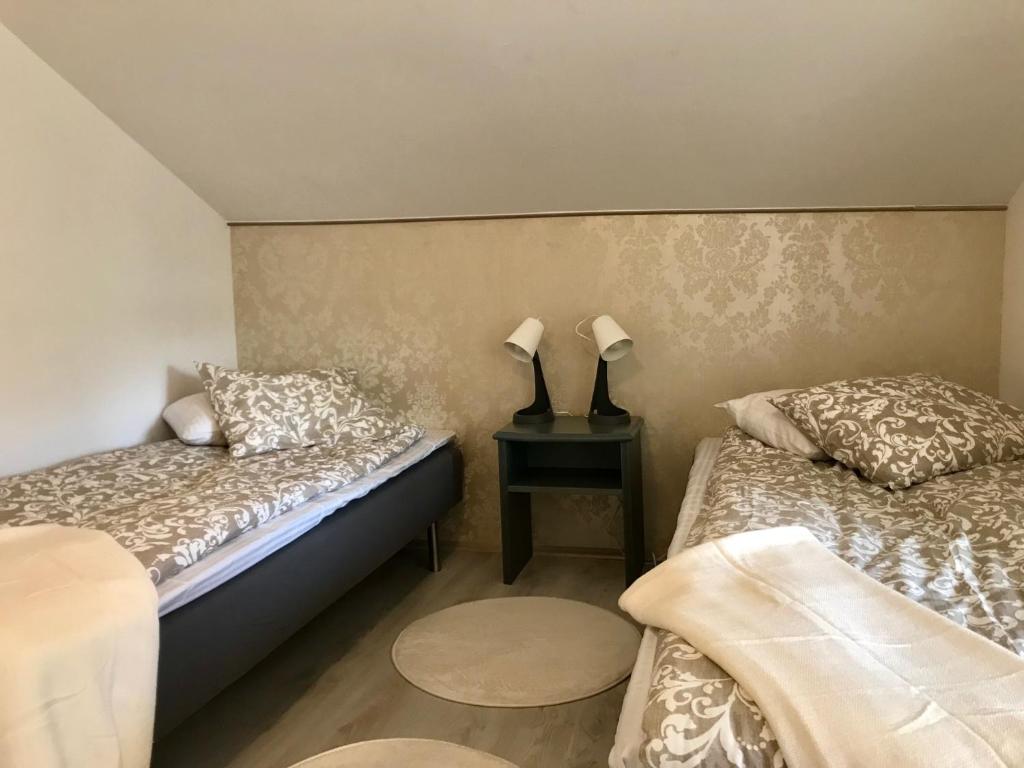 ein Schlafzimmer mit 2 Betten und einem Tisch mit 2 Lampen in der Unterkunft Rymlig lägenhet i avdelat hus med egen parkering in Käglinge