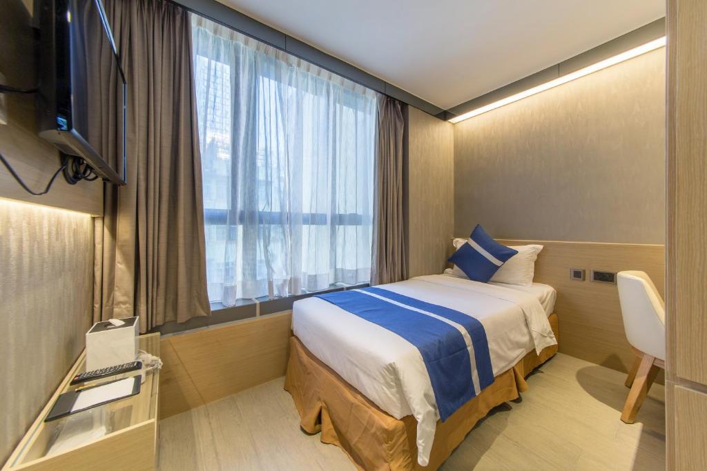 A bed or beds in a room at Lumine Hotel