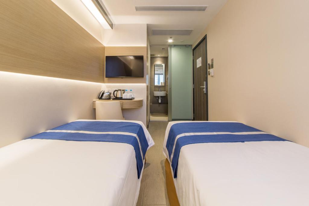 A bed or beds in a room at Lumine Hotel