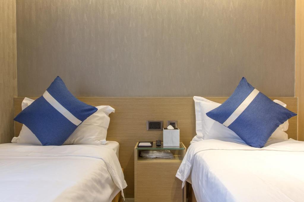 A bed or beds in a room at Lumine Hotel