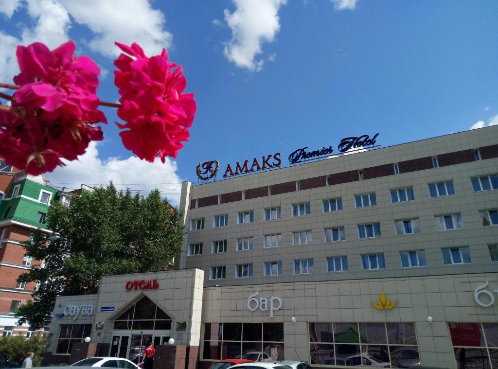 un edificio con flores rosas delante de él en AMAKS Premier Hotel, en Perm