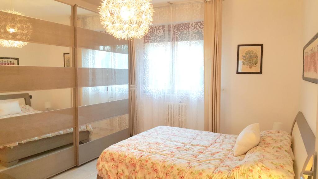 una camera con letto e lampadario a braccio di Casa del Sole - Sunshine Home a Marina di Pisa