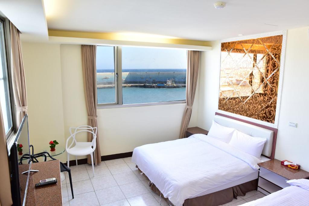 um quarto de hotel com uma cama e uma grande janela em 富岡休閒會館 Fugang INN em Taitung City